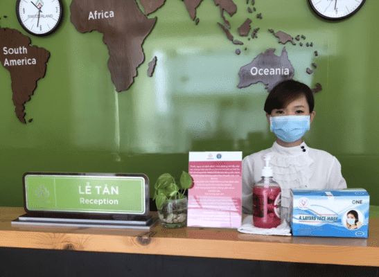 Hình ảnh nhân viên lễ tân đeo khẩu trang khi tiếp khách tại Nasoco